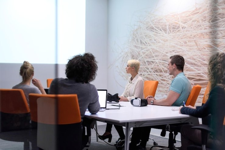 Colleagues seated around a meeting table in a modern office