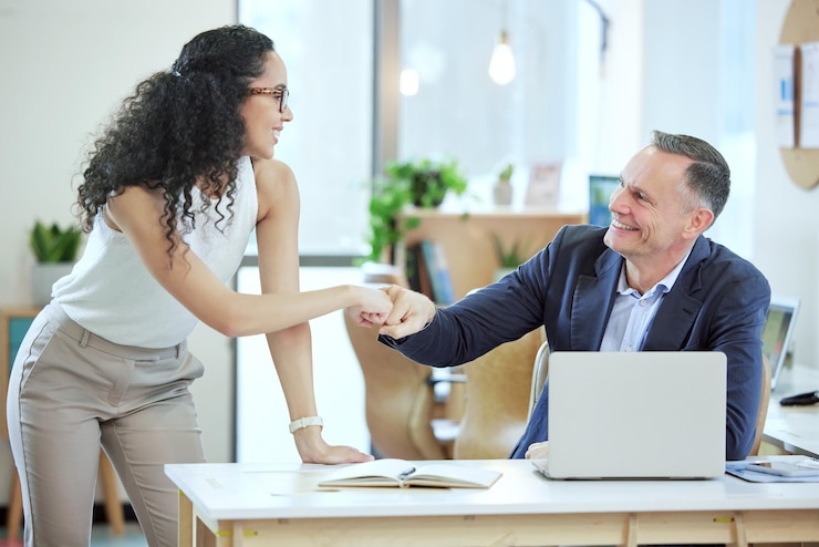 Two colleagues greeting each other with a handshake in an office